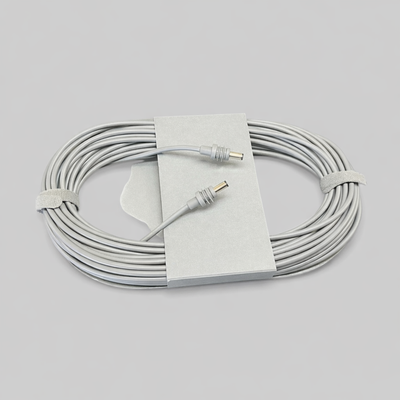 Top-down photo of an Original Starlink 15-meter DC-to-DC cable for the Starlink Mini, coiled and secured with velcro straps, showing both connectors and cardboard holder on a neutral grey background