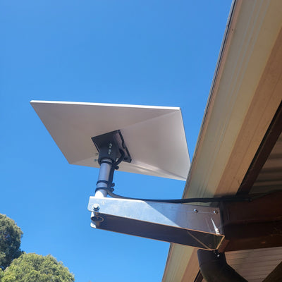 A photo of a Starlink Gen 3 Wall Mount kit under an eave in a residential setting. 